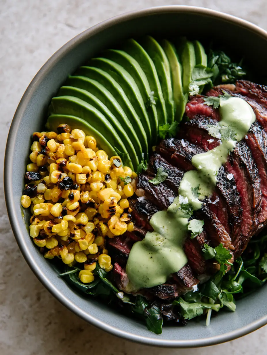 Close-up of a seared steak and avocado bowl with cilantro cream drizzle. (Whole30 Steak Bowl)