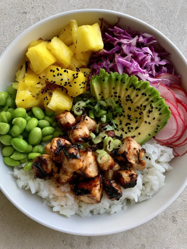 Close-up of a white ceramic bowl filled with fluffy rice, grilled chicken cubes, and fresh pineapple chunks for a Hawaiian Chicken Bowl.