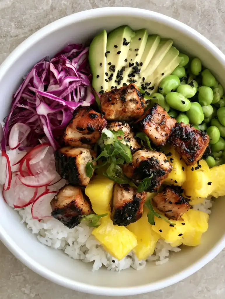 A Hawaiian Chicken Bowl topped with black sesame seeds, scallions, and perfectly sliced radishes on a stone background.