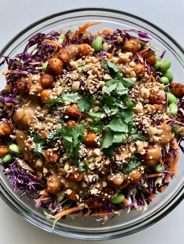Overhead view of a Thai Chickpea Salad with orange julienned carrots, green edamame, and golden charred chickpeas.